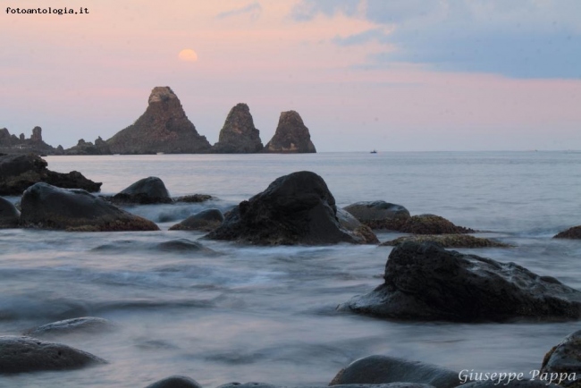 Luna piena sorge sopra le Isole dei Ciclopi